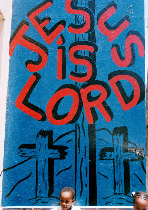 Två barn vid en målning där det står "Jesus is my lord"