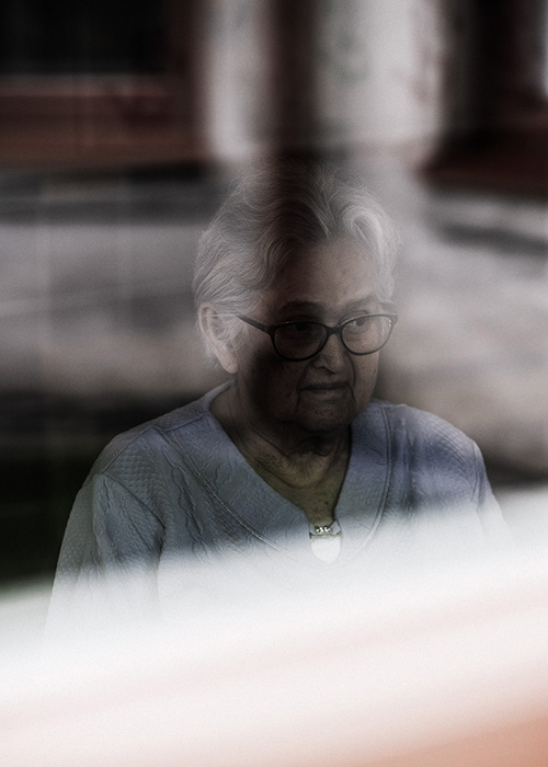 En äldre kvinna vid ett fönster