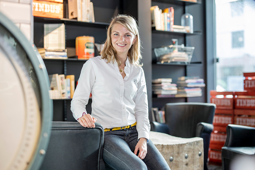En kvinna sitter på ett armstöd på ett kontor