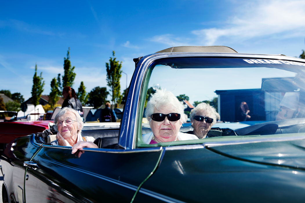 Tre tanter sitter i en cabriolet