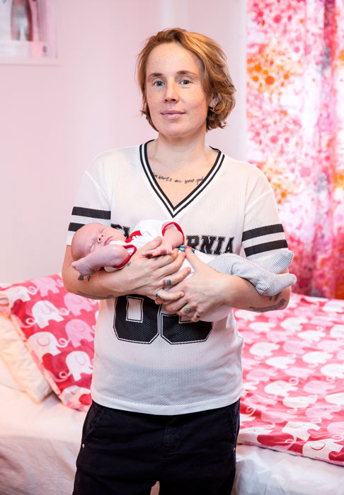 En förälder med sin baby i famnen