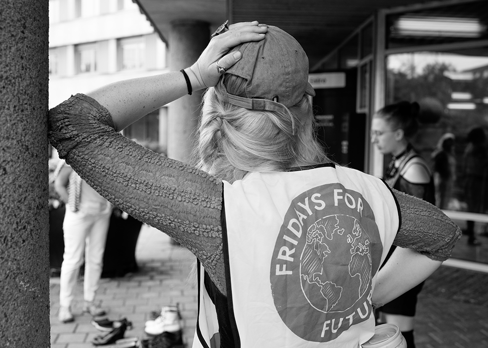 En kvinna lutar sig mot en stolpe