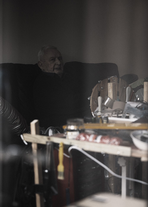 En äldre herre sitter i sin soffa