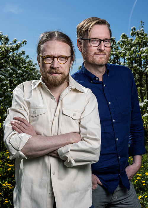Två män poserar utomhus